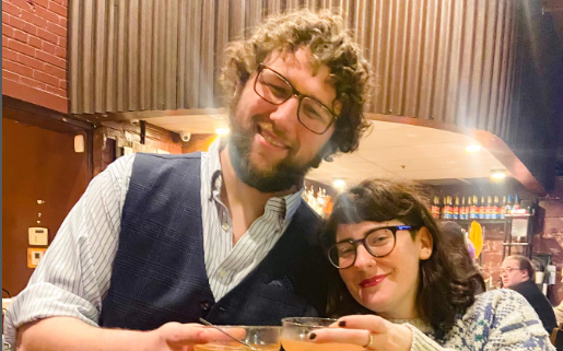 Two people inside The Rook & Pawn clinking glasses.