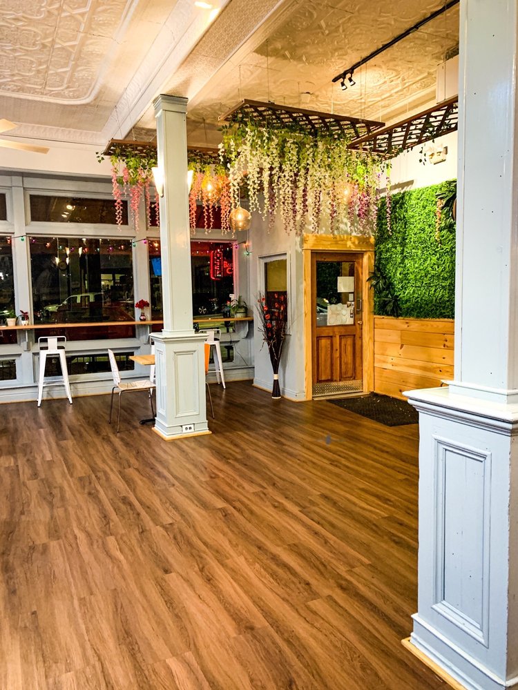 Inside of Bubble Cafe with wood floors and hanging plants.