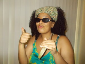 Hannah wearing the bandana and sunglasses eating a popsicle