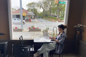 Me sitting at a coffee shop reading a newspaper.